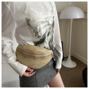 Mini sac ceinture en paille tressée beige porté avec une tenue décontractée chic