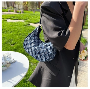 Détail du sac hobo en denim bleu avec motif à damier et finitions à bords effilochés