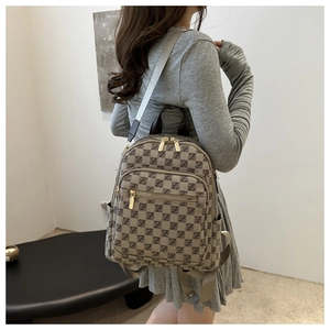 Detailed view of khaki monogram backpack featuring geometric Z pattern and gold hardware