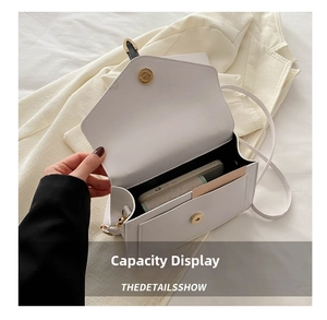 Detail view showing interior capacity of a white leather crossbody bag with magnetic buckle