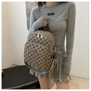 Close-up of a stylish plaid backpack with gold zippers and adjustable nylon straps