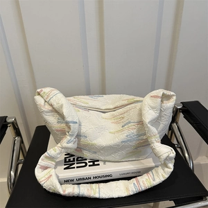 Sac croissant en nylon blanc avec surpiqûres colorées et texture gaufrée sur chaise