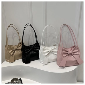 Vue détaillée de quatre sacs à bandoulière en kaki, noir, blanc et rose avec gros nœud