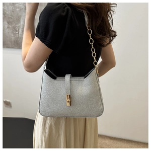 Sac hobo argenté à paillettes avec chaîne dorée et fermoir pivotant sur un modèle