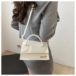 Dettaglio della mini borsa in pelle verniciata bianca con logo oro e tracolla regolabile