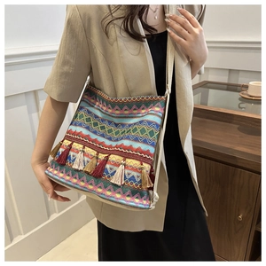 Detail of bohemian tote bag with colorful geometric patterns and decorative tassels