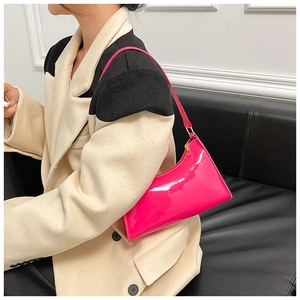 Detail of rose pink glossy leather shoulder bag with sleek metal zipper and strap