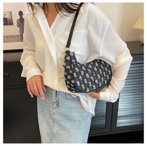 Détail du sac hobo en tweed noir et blanc avec bords effilochés et bandoulière
