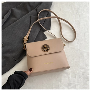 Detail of the vintage beige crossbody bag with round metallic buckle and FANYISSA logo