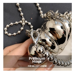 Detail of silver heart metal bag with lobster clasp and beaded chain strap