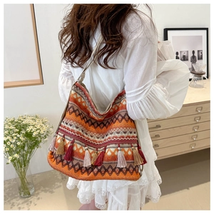 Close-up of bohemian woven tote bag with colorful geometric patterns and tassel details