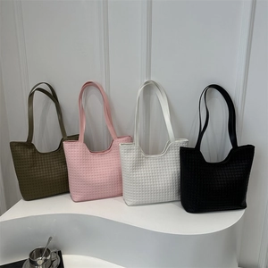 Minimalist woven tote bags in four colors shown on a white display stand for women