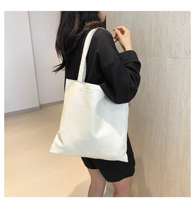 Dettaglio della borsa tote bianco panna con trama geometrica e finitura in ecopelle