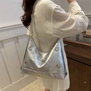 Silver metallic hobo bag with butterfly hardware and embossed texture on model