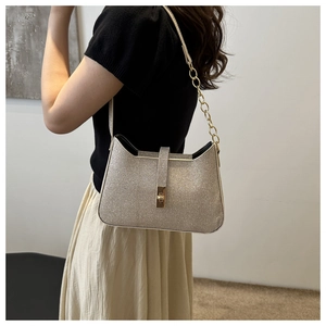 Gros plan du sac à bandoulière à paillettes or champagne avec chaîne en métal chic