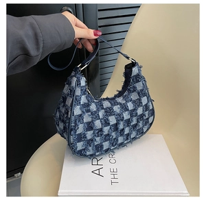 Détail du sac bandoulière en toile à carreaux bleu et blanc avec franges et boucles dorées