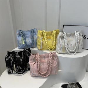 Borse shopper trapuntate con manici intrecciati e nappe in blu, giallo, bianco e rosa