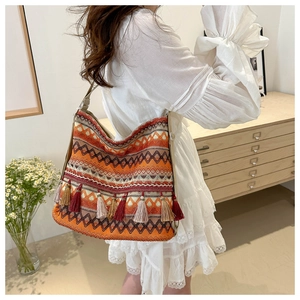 Detailed view of bohemian woven tote bag with colorful geometric patterns and tassels