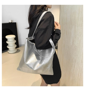 Borsa tote geometrica argento indossata, mostra la capienza e la trama metallica futuristica