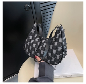 Détail du sac croissant en toile damier montrant la texture effilochée et la bandoulière