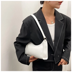 Detailed view of a white minimalist half-moon underarm bag with smooth leather texture