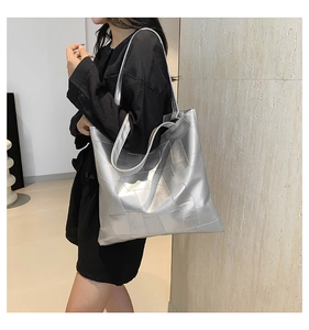 Dettaglio della borsa tote grande argento metallizzato con trama trapuntata indossata