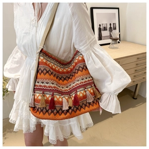 Close-up of bohemian woven tote bag featuring colorful tassels and geometric wave pattern