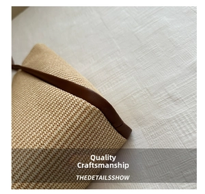 Detail showing the straw woven texture and dark brown leather piping on the summer tote bag