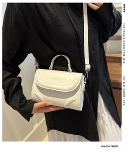 Close-up of a white leather square handbag with Fashion & Bag embossed logo and handle