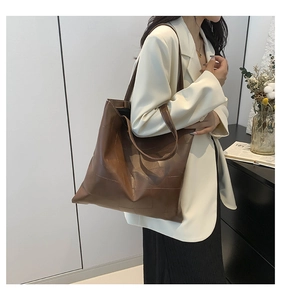 Dettaglio di una borsa tote marrone capiente con cuciture a vista e stile minimalista