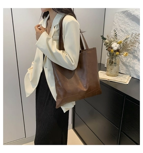 Dettaglio della borsa tote grande in pelle marrone scuro con cuciture geometriche