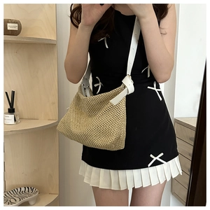 Détail du sac cabas en paille tissée avec bandoulière en cuir blanc et boucle réglable