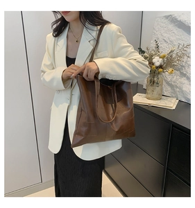 Dettaglio della trama della grande borsa tote marrone cioccolato in pelle opaca