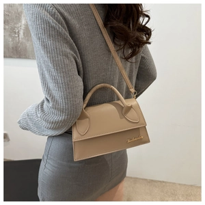 Detail showing beige crossbody bag with lychee texture leather and golden logo