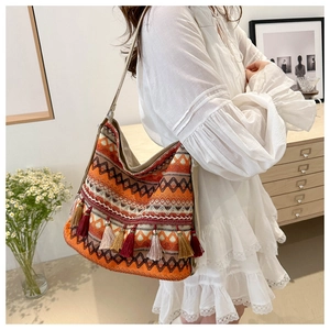 Close-up of bohemian woven tote bag with colorful geometric patterns and decorative tassels