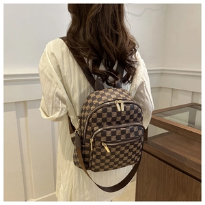 Detailed side view of checkered backpack with gold hardware and multiple zipper pockets