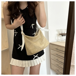 Sac cabas en paille avec bandoulières en cuir blanc porté par un mannequin à domicile