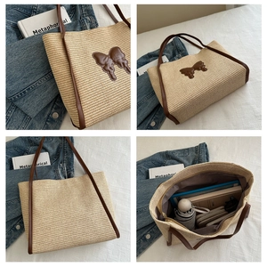 Macro view of woven straw tote bag with brown leather butterfly detail and large interior