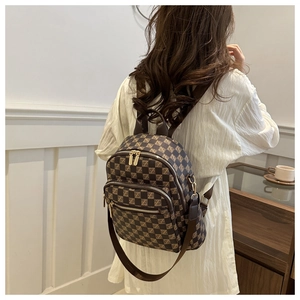 Detail view of stylish brown checkered backpack featuring adjustable leather straps