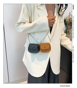 Detail of mini chain crossbody bags with vintage geometric print on a white blazer