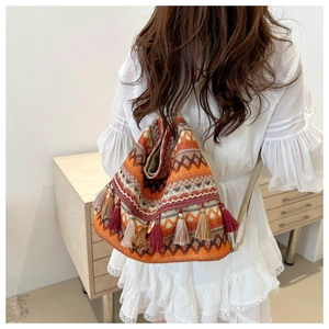 Close-up of bohemian woven bag featuring vibrant ethnic patterns and colorful tassels