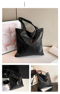 Dettaglio della borsa tote grande nera con patchwork geometrico e trama in pelle sintetica
