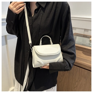 Close-up of white PU leather bag showing FASHION & BAG embossing and silver hardware