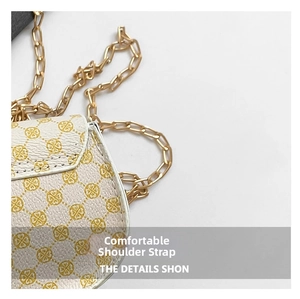 Close-up of golden chain strap and yellow clover pattern on white PU leather saddle bag