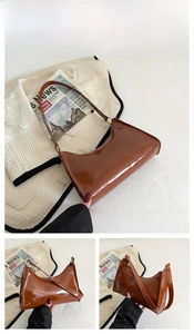 Detailed side view of a brown glossy patent leather shoulder bag with sleek straps