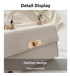 Detail view of white crocodile pattern leather texture and golden rectangle twist lock