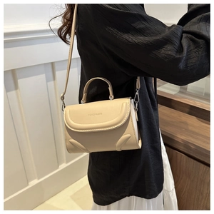 Chic beige crossbody bag with fashion letter embossing shown on a stylish model