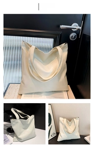 Dettaglio della grande borsa tote bianca con motivo geometrico a rilievo e doppi spallacci