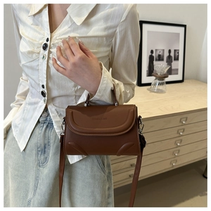 Brown PU leather bag detail showing the fashion text logo and textured flap cover