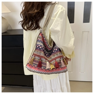 Detail shot of bohemian tote bag with colorful woven patterns and vibrant hanging tassels